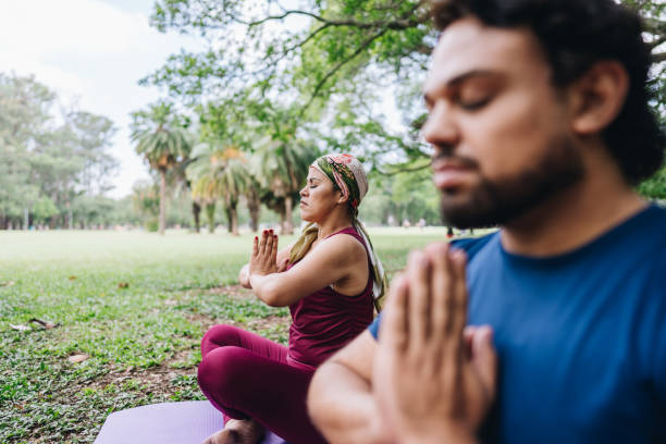 istock Couple doing yoga at park 1929972594