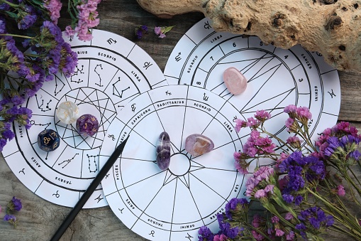Flat lay composition with zodiac wheels and astrology dices on wooden table