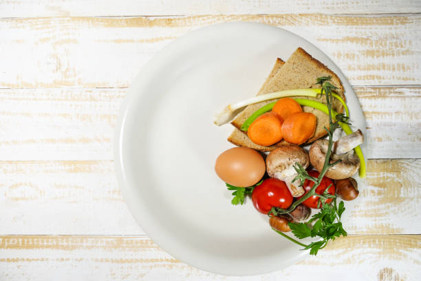 Diet concept interval fasting or intermittent fasting, one third of a plate is filled with healthy food, the rest is empty to show the eating and fasting time period, top view from above, copy space