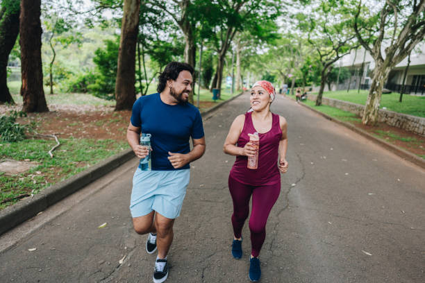 istock Couple talking and jogging at public park 1930005926