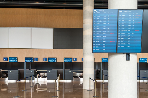 Flight information board at the empty check-in area at the airport.