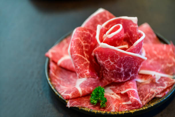 istock Sliced wagyu marbled beef for yakiniku on plate on black background, 1930089542