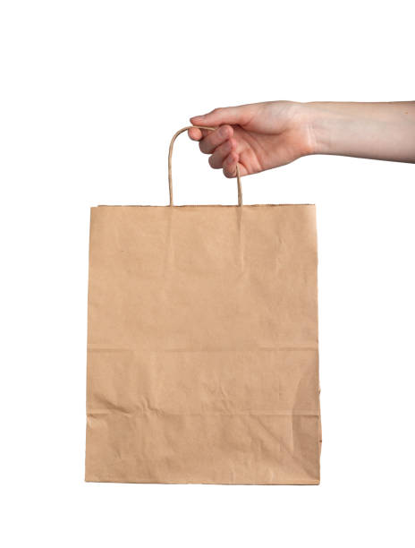 Kraft paper bag in hand, blank package mock up, mockup isolated on white