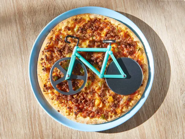 Kitchen pizza cutter like a bicycle on wooden table