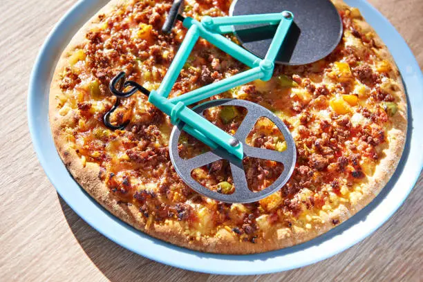 Kitchen pizza cutter like a bicycle on wooden table