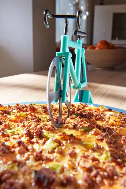 Kitchen pizza cutter like a bicycle on wooden table