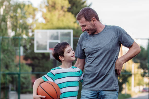 istock Morning Training. Father And Son Playing Basketball. Conversation between father and a son 1930094796