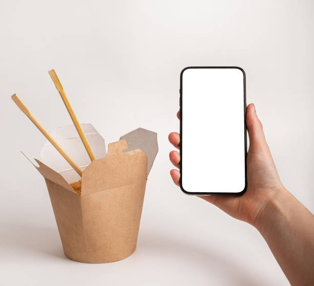 istock Hand holding mobile phone screen mockup, smartphone, cellphone for ordering Asian food 1930096885