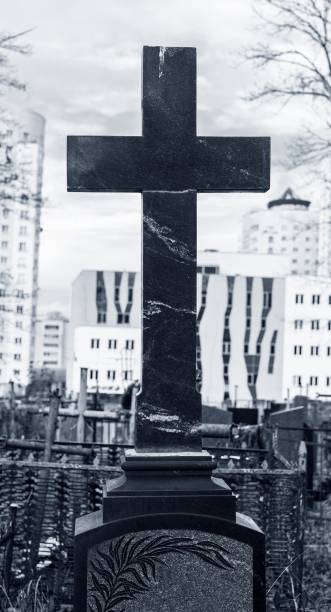 istock Stone cross at cemetery. Religious symbol over tombstone 1930097415