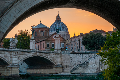 Rome, Lazio, Italy - 09 June 2021:\nDon't miss the splendid view of San Pietro with the waters of the Tiber reflecting the light of the setting sun, which is undoubtedly one of the most memorable images of those who visit this splendid capital.