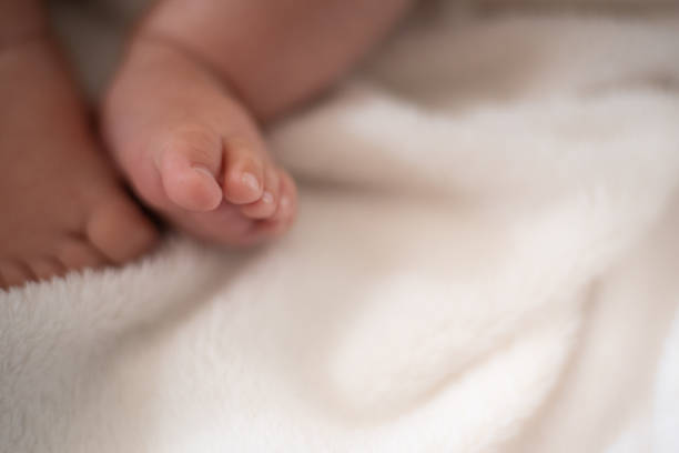 Baby's feet over white blanket
