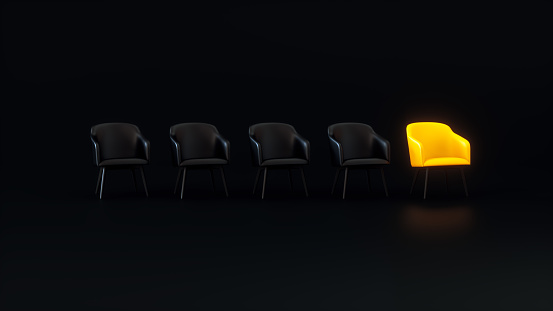 A Yellow Glowing Chair That Stands Out From the Black Chairs Crowd on a Dark Studio Background. Business concept. 3D rendering.