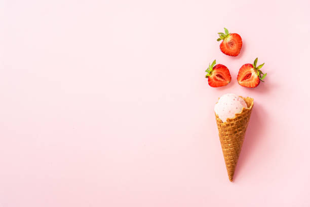 Strawberry ice cream. Ice cream cone top view on pink.