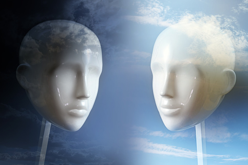 Negative versus positive thinking and emotion, psychology concept shown with two neutral colored mannequin heads and corresponding dark and light sky, copy space