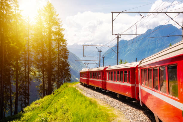 istock Red train moving in beautiful green summer forest in Switzerland 1930143800