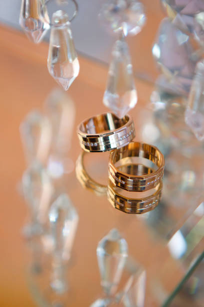 istock Wedding rings for weddings lie on a mirror reflecting surface. 1930145345