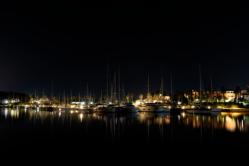 Long-exposure photo at a harbor, featuring a captivating view of boats and a beautiful reflection