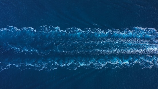 Aerial top down drone view of water foam trace behind a crude oil tanker
