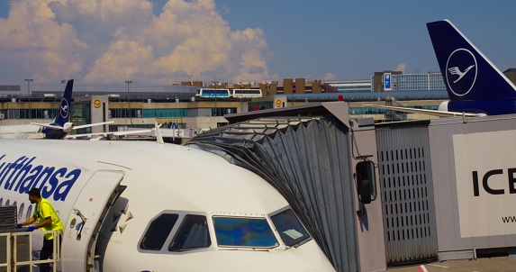 Frankfurt, Germany - May 2, 2023: Lufthansa airline, airport worker put out baggage from plane. Lufthansa airline cares about passengers and they baggage. Chose Lufthansa airline to feel calm flight