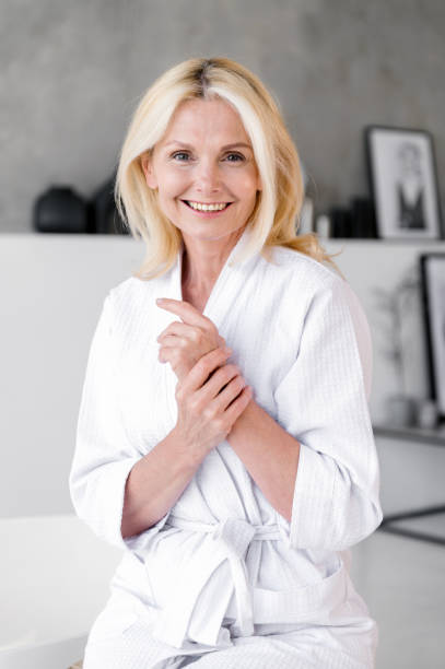 istock Smiling happy middle aged woman touching soft skin on hands 1930213494