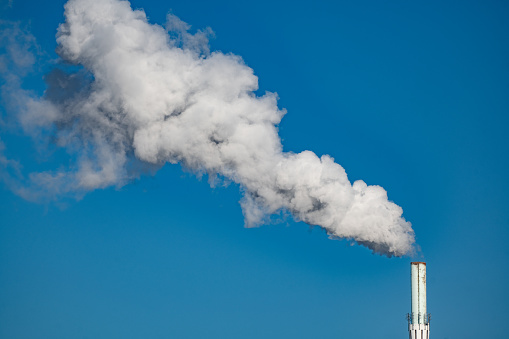 Smoke rises from an industrial chimney