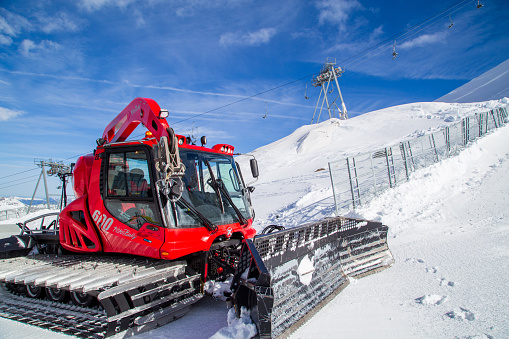 The red snow groomer prepares the ski slope on the Hintertux Glacier in the Zillertal - Austria