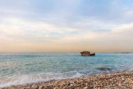 A sea wave washes the stony shore, as if a mother's hand is stroking her child. The beauty and grace of nature pleases the eye and inspires as all.