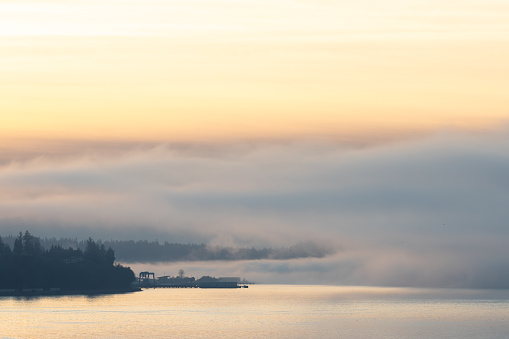 The Mukilteo Ferry dock peaks through the fog on the puget sound on a foggy winter afternoon