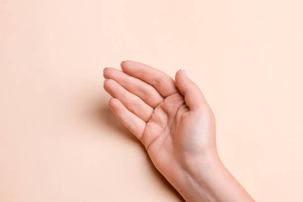 istock Female hand with palm up on beige background 1930364974