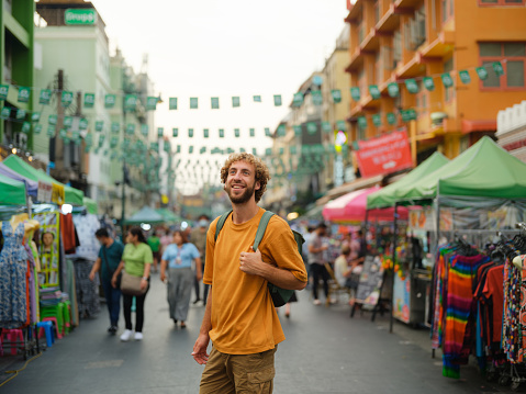 Cheerful man walking on Khao San road in Bangkok  during vacation