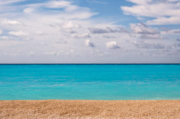 Sumer sea scenery at beach with clouds, dramatic sky, waves, sand and turquoise water
