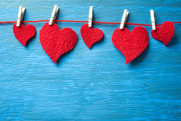 istock Red hearts hanging on a thread with clothespins on a light blue background. 1930499374
