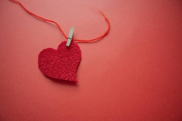 istock Beautiful heart on paper held by a red thread with a clasp. 1930515991