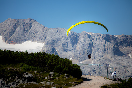 One random person is paragliding in Dachstein, Hallstatt with beautiful mountain and sky background