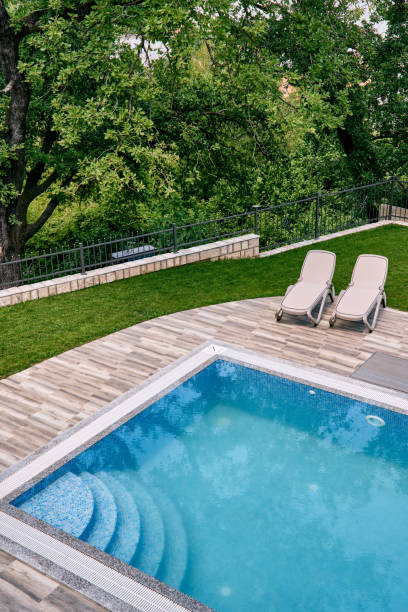 istock Two sun loungers stand next to a rectangular pool in the garden. Top view 1930557288