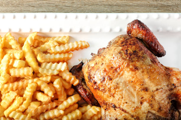 istock Whole grilled chicken and fries on ceramic plate 1930674774