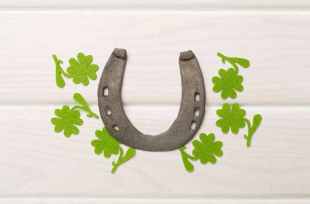 istock Horseshoe with clover on wooden background, top view. St. Patricks day concept 1930691676