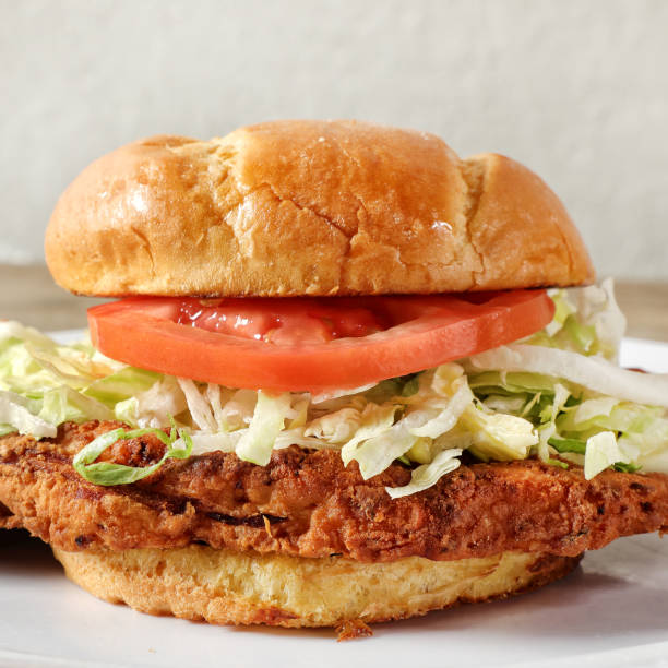 Vegan sandwich homemade bread, falafel, iceberg lettuce, tomato, cucumber, salsa. Rye veggie burger on white plate on blurred background. Plant based food concept. healthy fast food.