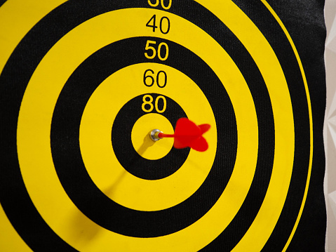 Dartboard with dart arrow in bullseye, close up shoot