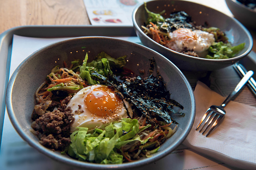 Korean delicious spicy salad of seaweed and spinach with fried egg