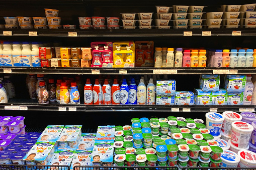 A well-organized shelf in a Hoboken, NJ, USA supermarket, displaying a variety of yoghurts and fermented milk products, offering a selection of delicious and healthy dairy options.