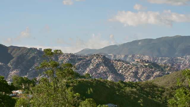 Aerial full panning view of western and downtown areas of Caracas city valley with El Avila Mountain at the background