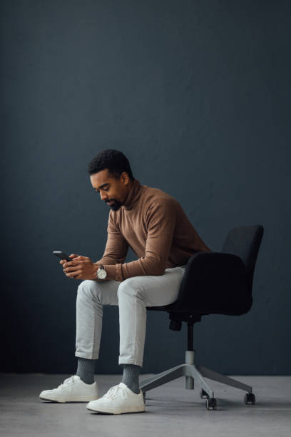 istock Businessman Sitting on an Office Chair and Using a Mobile Phone 1930804523