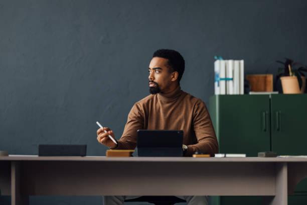 istock Young Businessman Sitting at His Desk and Using Tablet in Office 1930805046