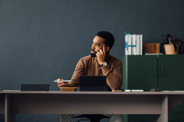 istock Young Businessman Sitting at His Desk and Using Tablet in Office 1930805051