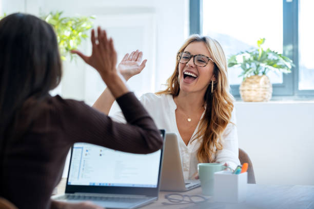 istock Two successful young businesspwomen celebrating while holding up their right hands on coworking place. 1930810756