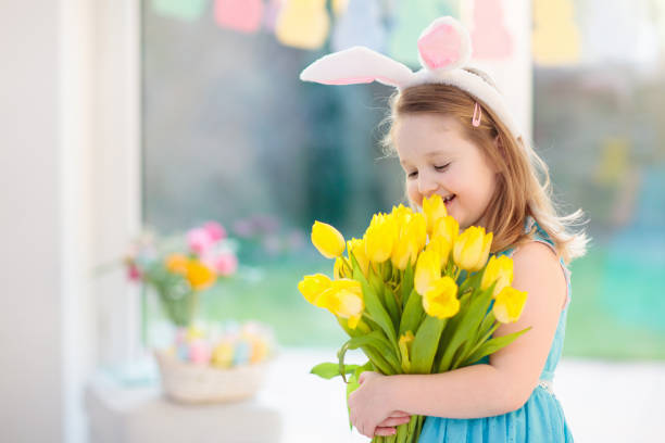istock Little girl in bunny ears on Easter egg hunt 1930889564