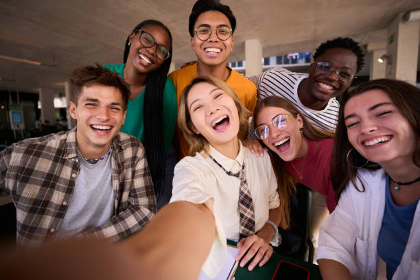 istock A large group of smiling and cheerful young multiracial university students taking a selfie 1930891103
