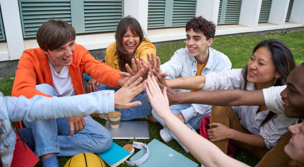 istock Laughing multiracial young people gathered in circle joining hands celebrating academic success. 1930899323