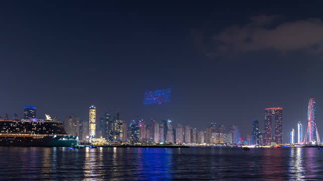 Time lapse of drone LIGHTING show between Jumeirah beach and blue water Ain wheel at night.
